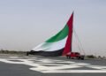 A citizen violates the expectations of artificial intelligence by turning the largest flagpole of the UAE into a Guinness record.