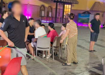 Rival stall owner sprays water at crowded neighboring stall in Vietnam tourist site