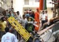 Building collapse in New Delhi kills 1 and traps dozens of others