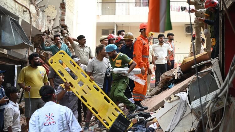 Building collapse in New Delhi kills 1 and traps dozens of others