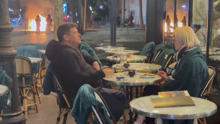 Watch: Blasé French couple smoke and drink while riots rage outside